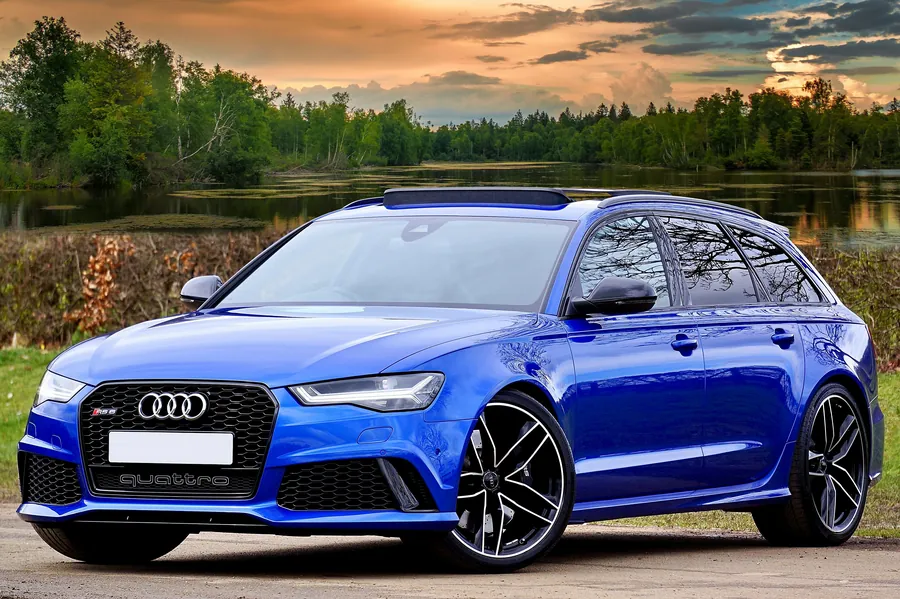 Blue Audi RS6 Avant parked by a lake